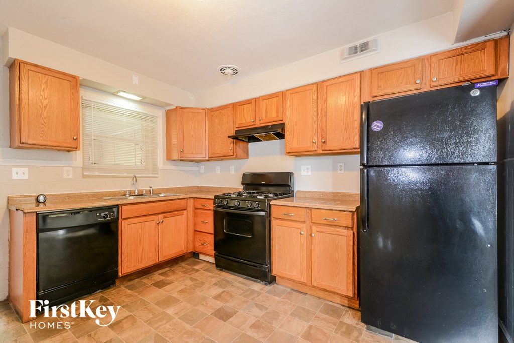 a kitchen with black appliances and wooden cabinets
