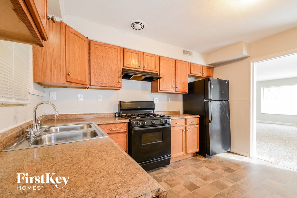 a kitchen with black appliances and wooden cabinets
