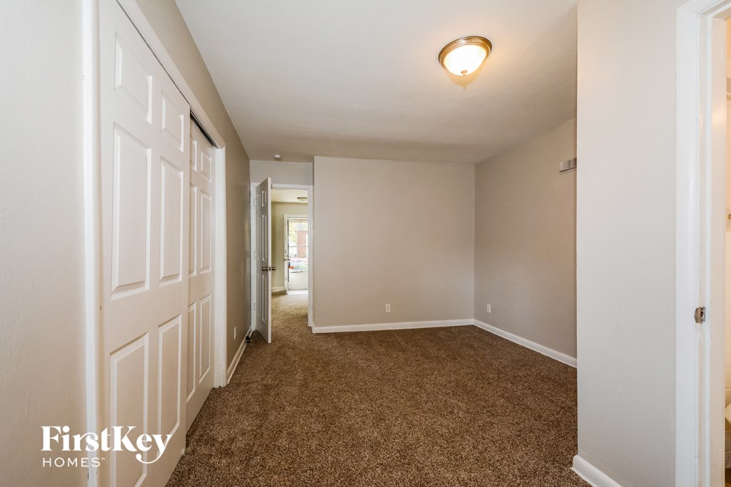 a bedroom with a carpeted floor and a white door