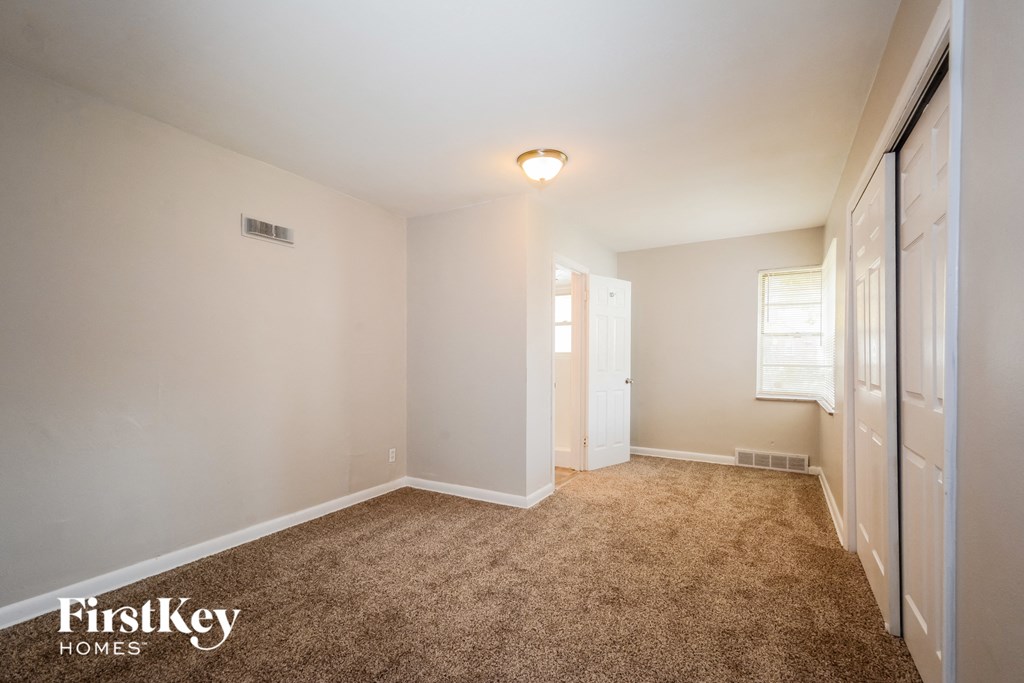 a master bedroom with a carpeted floor and a walk in closet
