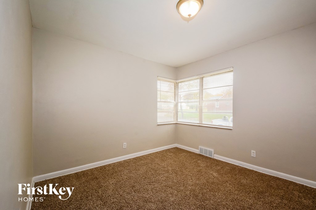 a bedroom with a carpeted floor and a window