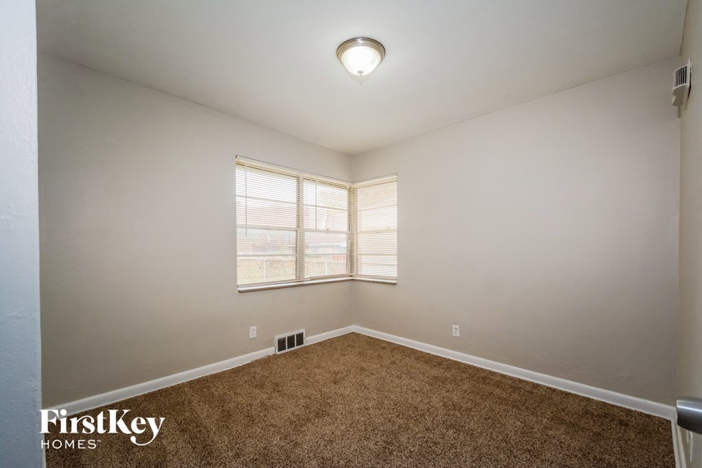 the spacious living room with carpeting and a large window