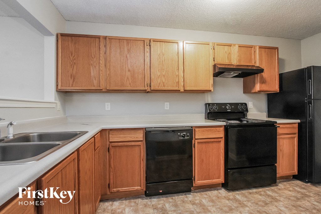 a kitchen with black appliances and wooden cabinets