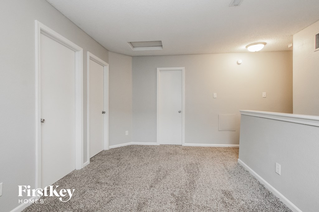 a spacious living room with white carpet and white doors