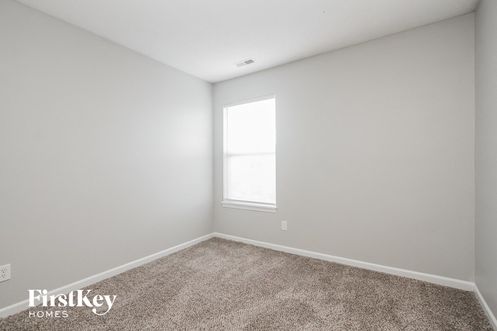 a white room with carpet and a window