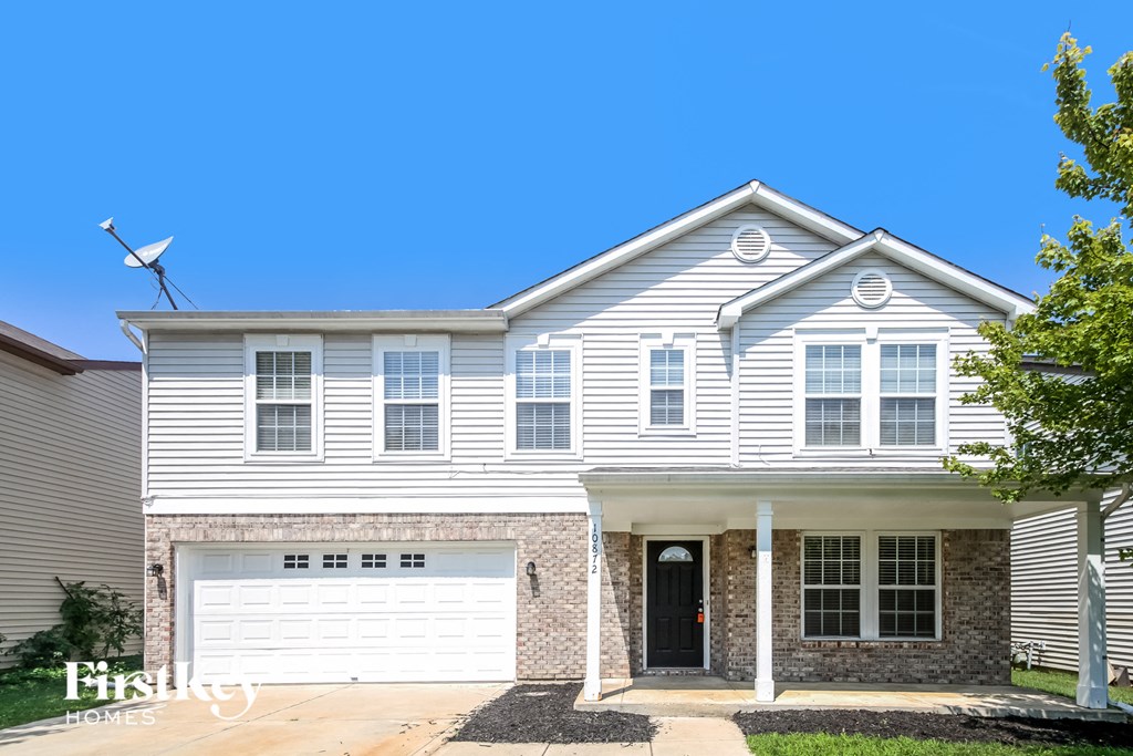 A two-story house with a garage and a front porch.