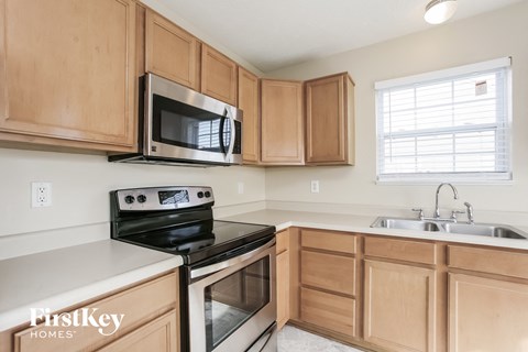 a kitchen with wood cabinets and black appliances and a microwave