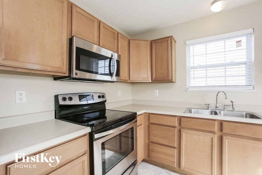 a kitchen with wood cabinets and black appliances and a microwave