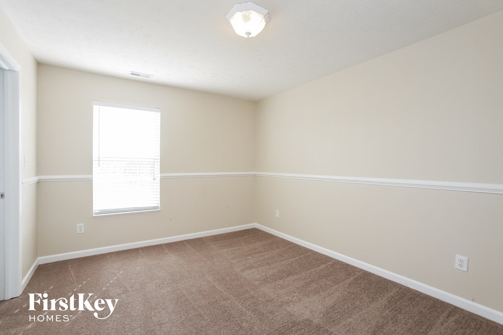 a bedroom with a carpeted floor and a window