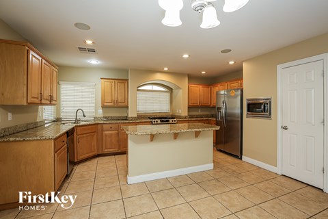 A kitchen with wooden cabinets and a granite countertop.