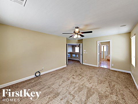 a living room with carpet and a ceiling fan