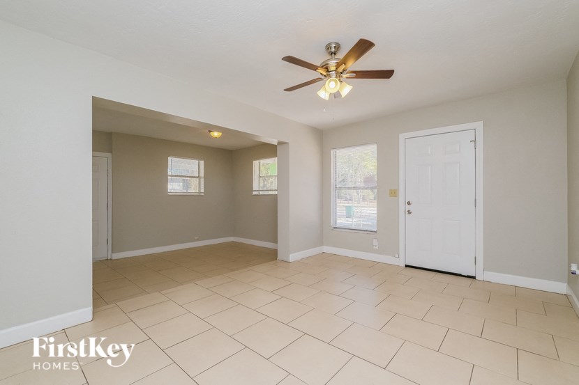 A spacious room with a ceiling fan and tiled flooring.
