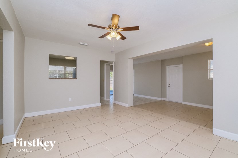 A spacious room with a ceiling fan and tiled flooring.