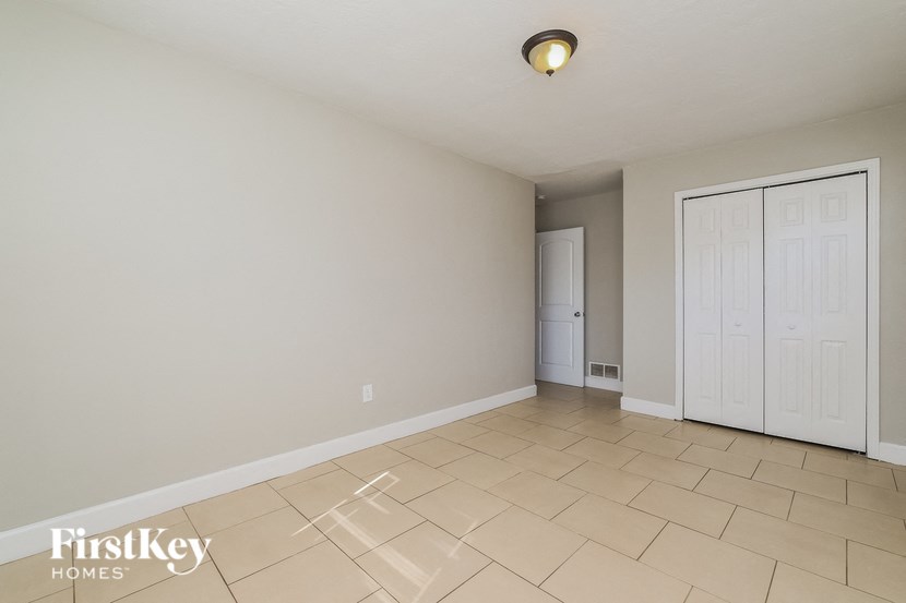 A room with a white door and a light on the ceiling.