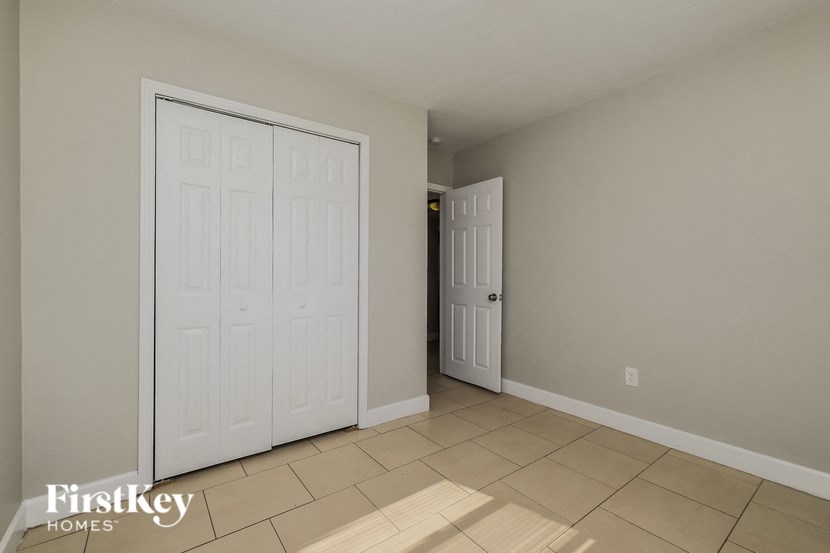 A white door is in a room with a tan floor.