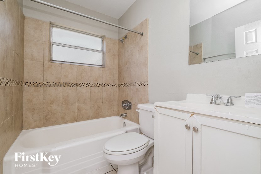 A white bathroom with a tub, toilet and sink.