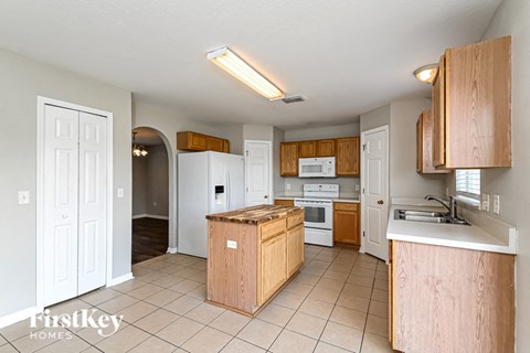 A kitchen with wooden cabinets and a white fridge.