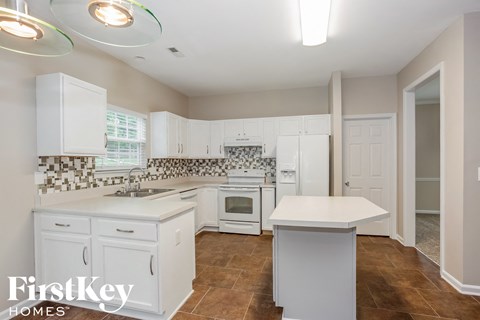 a white kitchen with white counters and white appliances and white cabinets