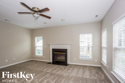 a living room with a fireplace and a ceiling fan