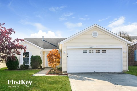 the front of a white house with a white garage door
