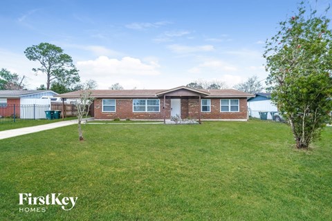 a brick house with a yard in front of it