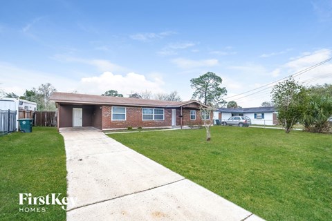 a brick house with a yard and a sidewalk