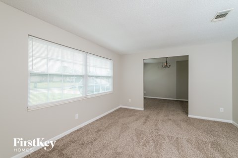 a spacious living room with carpet and a large window