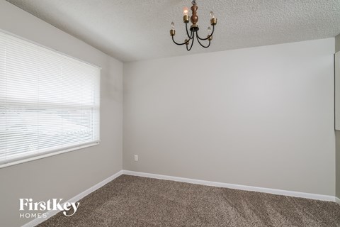 a bedroom with a large window and a chandelier