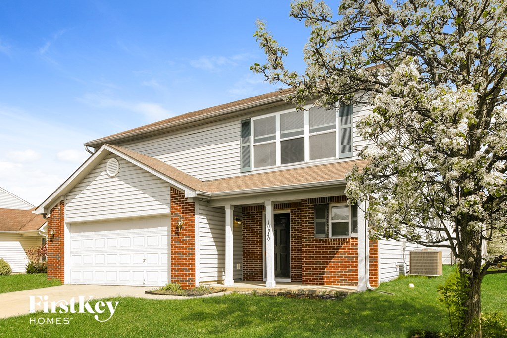 a white house with a tree in front of it