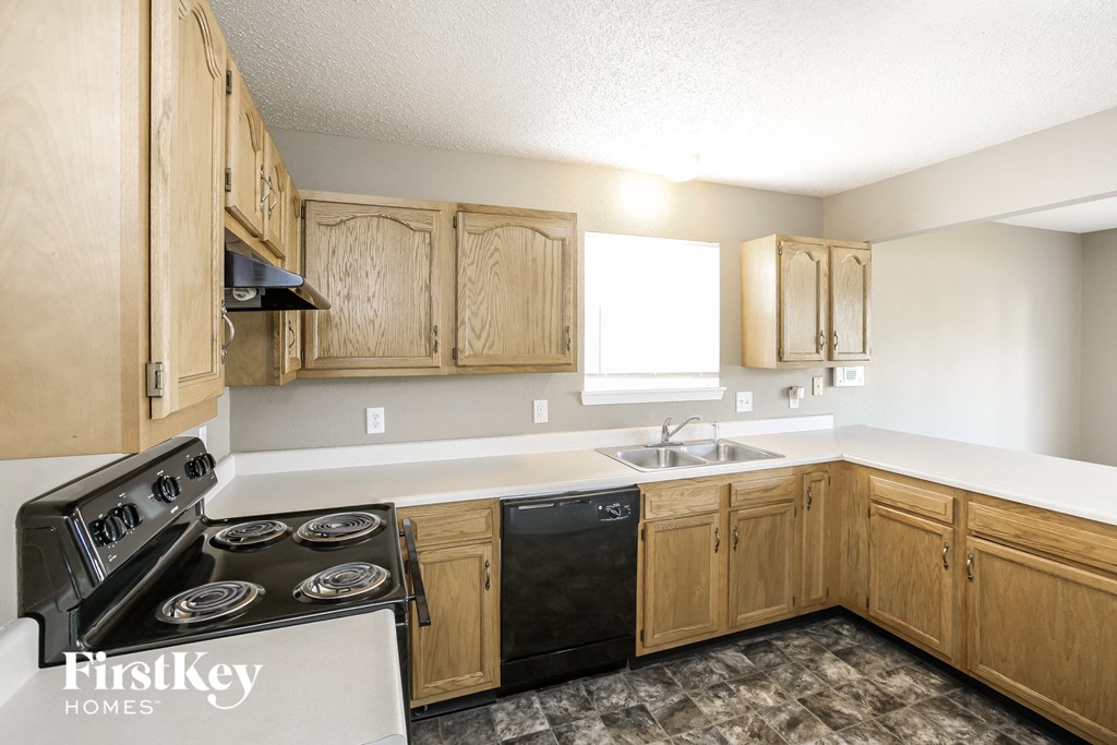 a kitchen with wood cabinets and a stove and a sink