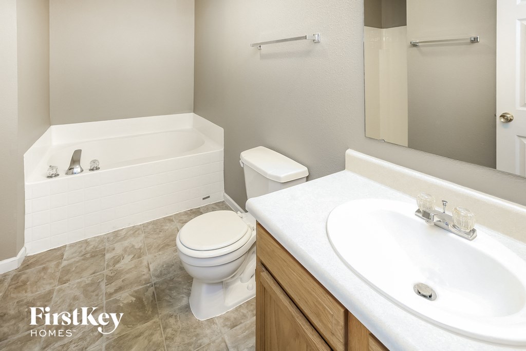 a bathroom with a toilet and a sink and a bath tub