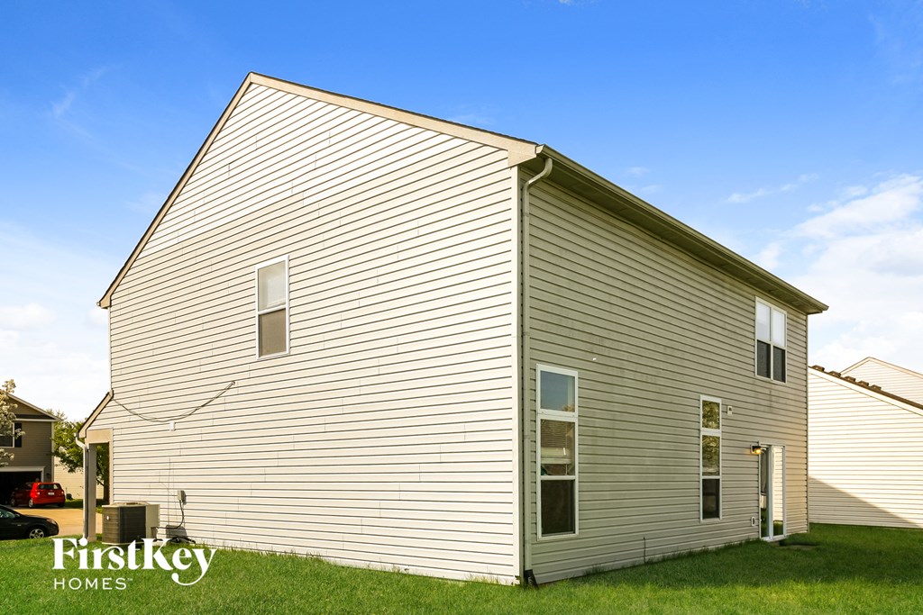 the outside of a house with white siding and a blue sky