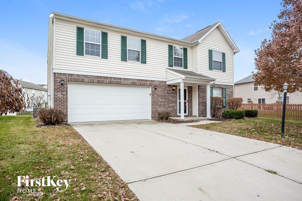 A two-story house with a garage and a driveway.