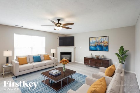 A living room with a white couch, a coffee table, a fireplace, and a painting on the wall.