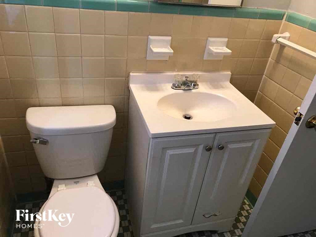 A white toilet and sink in a small bathroom.