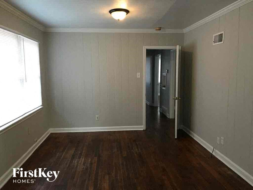 A room with wood flooring and a doorway leading to another room.