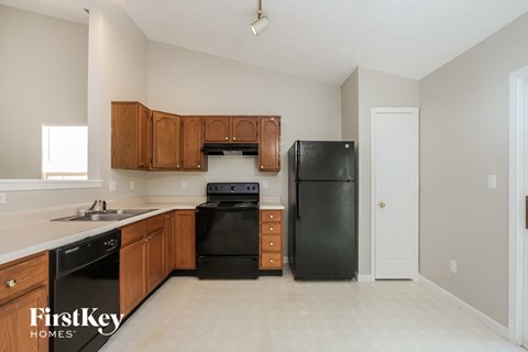 A kitchen with wooden cabinets and black appliances.