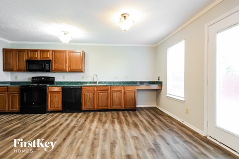 A kitchen with wooden floors and a FirstKey Homes logo.