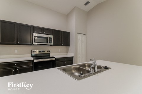 a kitchen with black cabinets and white counter tops and a sink