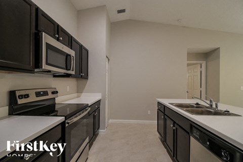 A kitchen with black cabinets and a white countertop.