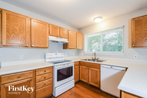A kitchen with wooden cabinets and a white dishwasher.