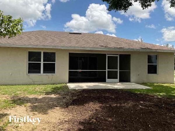 a small white house with a yard and a garage