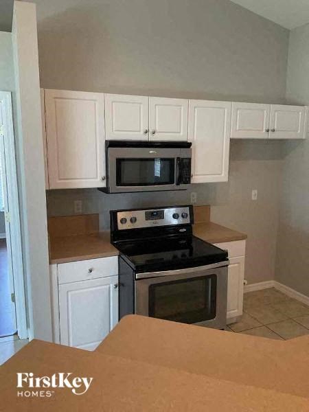 a kitchen with a stove microwave and white cabinets