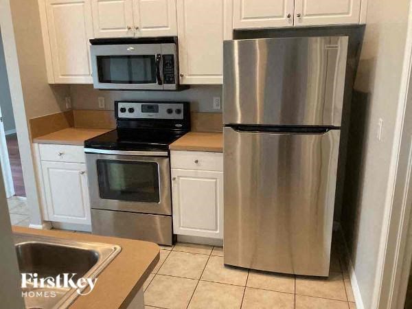 a kitchen with white cabinets and a stainless steel refrigerator
