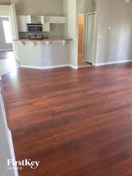 a living room with wood flooring in an empty house