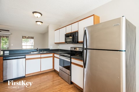 a kitchen with white cabinets and a stainless steel refrigerator