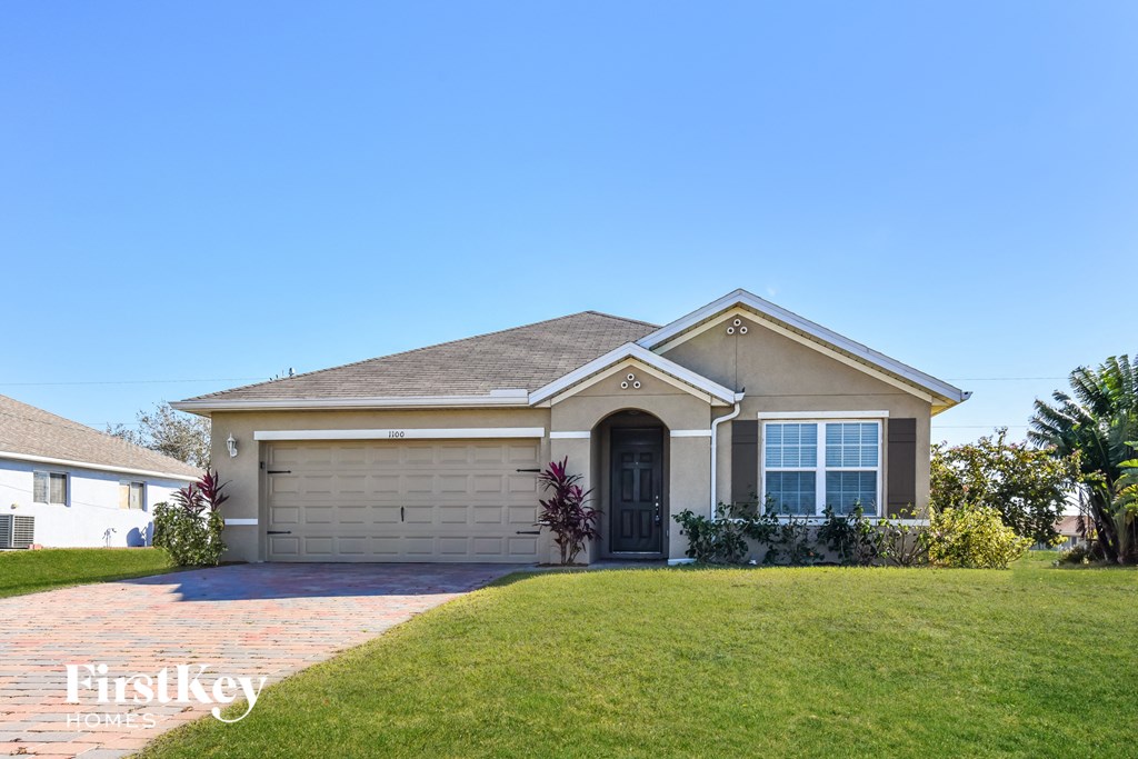 a house with a lawn and a blue sky