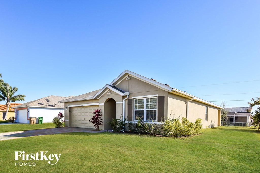 a beige house with a lawn in front of it