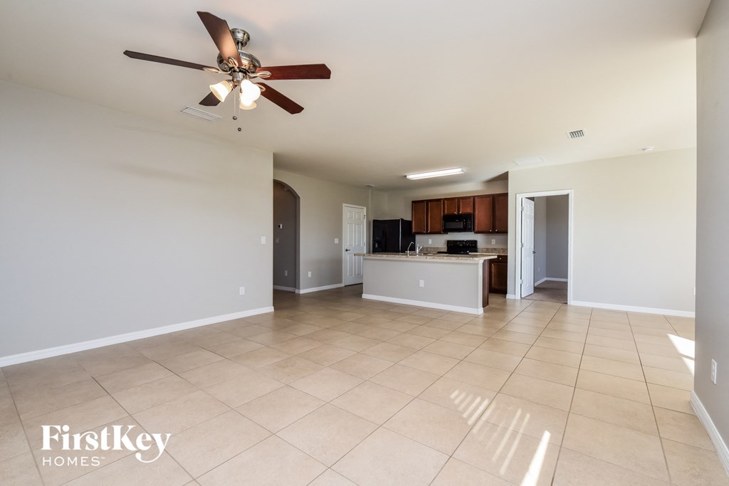 a kitchen and living room with tile flooring and a ceiling fan