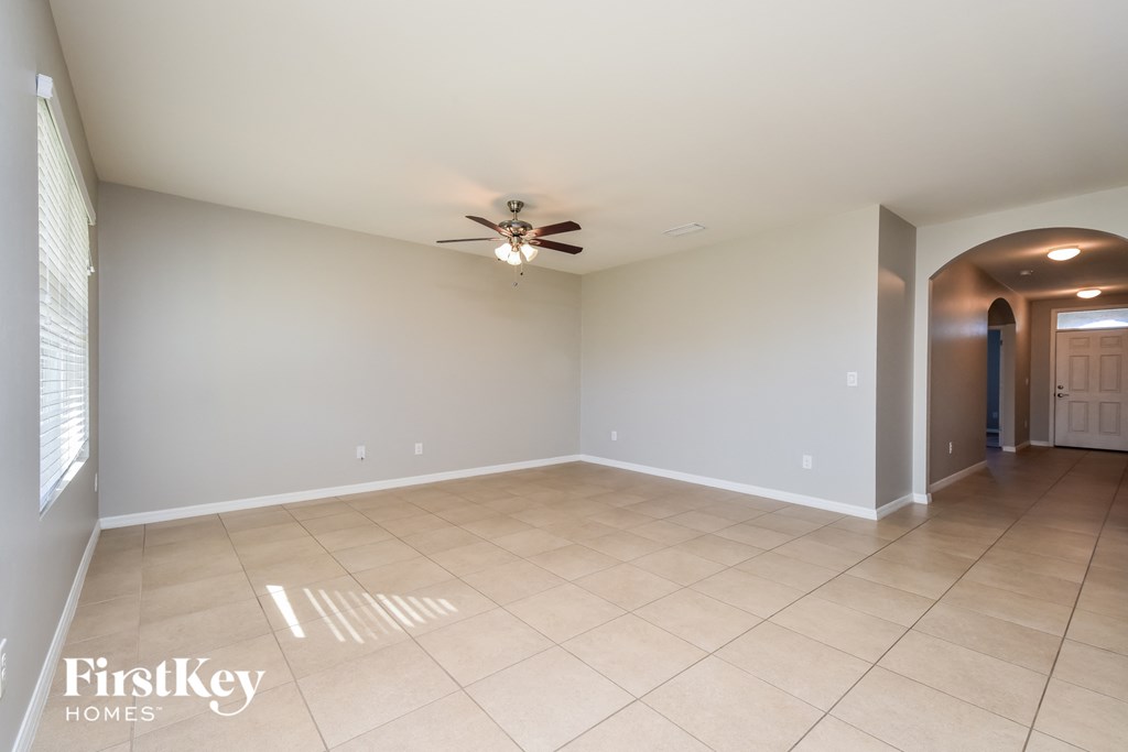 an empty living room with a ceiling fan